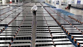 À Nankin, dans la province chinoise de Jiangsu, un ouvrier au milieu de batteries électriques pour automobiles.