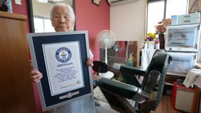 Shitsui Hakoishi , Japonaise de 108 ans, pose avec son certificat de coiffeuse la plus âgée du monde du Guinness des records, à Nakagawa, au Japon, le 5 mars 2025