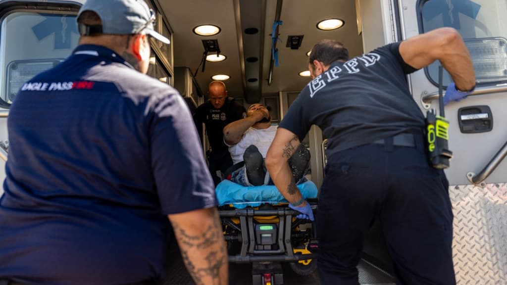 Des urgentistes portent secours à un homme qui travaillait sur un chantier, à l'extérieur, durant la vague de chaleur qui touche les États-Unis, à Eagle Pass, au Texas.