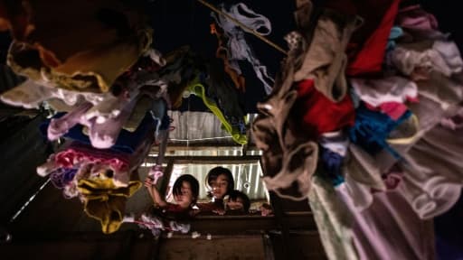 Des enfants observent une scène de crime à travers leur fenêtre à Manille, aux Philippines, le 16 février 2017 Des enfants observent une scène de crime à travers leur fenêtre à Manille, aux Philippines, le 16 février 2017