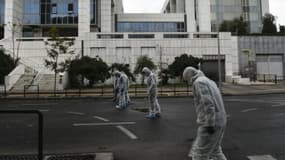 Des enquêteurs de la police grecque recherchent des indices après l'explosion d'un engin devant la cour de justice d'Athènes, le 22 décembre 2017