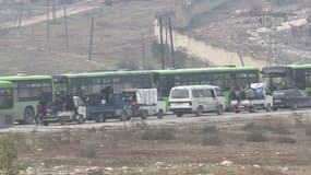 Les bus verts chargés de l'évacuation, attendant de pouvoir entrer à Alep.