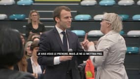 Une femme offre un collier avec un mini gilet jaune à Emmanuel Macron lors du Grand débat à Pessac