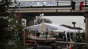 Une banderole indiquant "Les ultras de l'A64" est accrochée au-dessus de l'autoroute lors d'un blocus d'agriculteurs pour protester contre le protocole gouvernemental d'abattage obligatoire des troupeaux de bovins atteints de dermatose nodulaire contagieuse, à Carbonne, dans le sud-ouest de la France, le 22 décembre 2025.