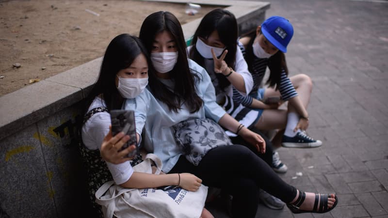 Des adolescents portant des masques de protection font un selfie, le 7 juin, à Séoul. 