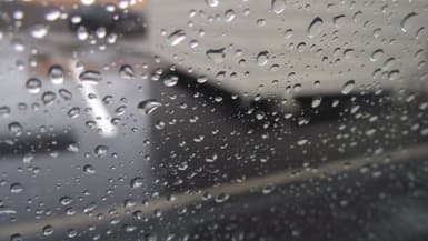 Photo de gouttes de pluies sur une vitre de voiture (Photo d'illustration).