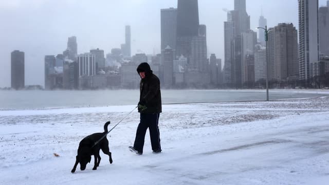 Un homme devant le lac Michigan au lever du soleil alors que les températures oscillaient autour de -8 degrés le 22 décembre 2022 à Chicago.