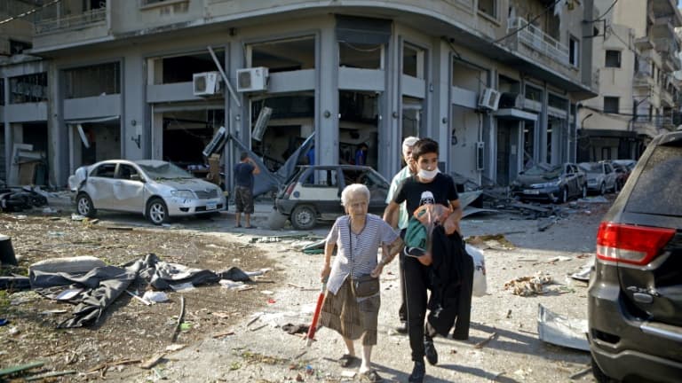 Une femme est évacuée du quartier de Mar Mikhaël, le 5 août 2020, le "coeur battant" de Beyrouth dévasté par les explosions de la veille