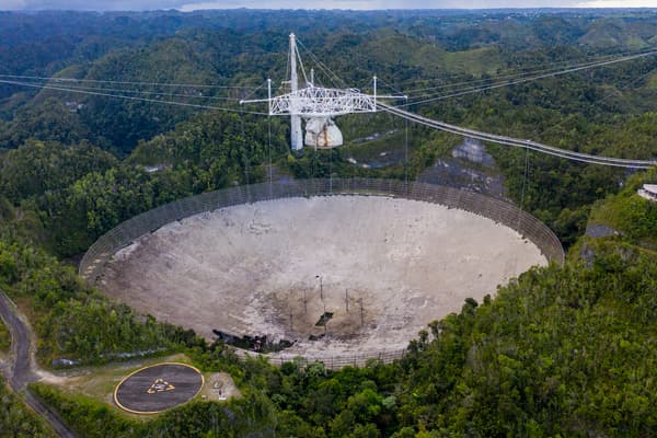 Cette vue aérienne montre l'antenne parabolique de l'Observatoire d'Arecibo à, Porto Rico, le 19 novembre 2020. Cette infrastructure a participé aux relevés des ondes gravitanionnelles.
