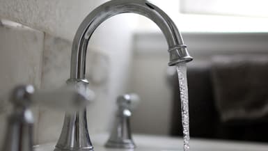 L'eau coule d'un robinet. (Illustration)