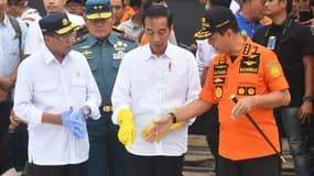 Le ministre des Transports Budi Karya Sumadi (à gauche) avec le Président indonésien Joko Widodo (au centre) inspectant les débris de l'avion.