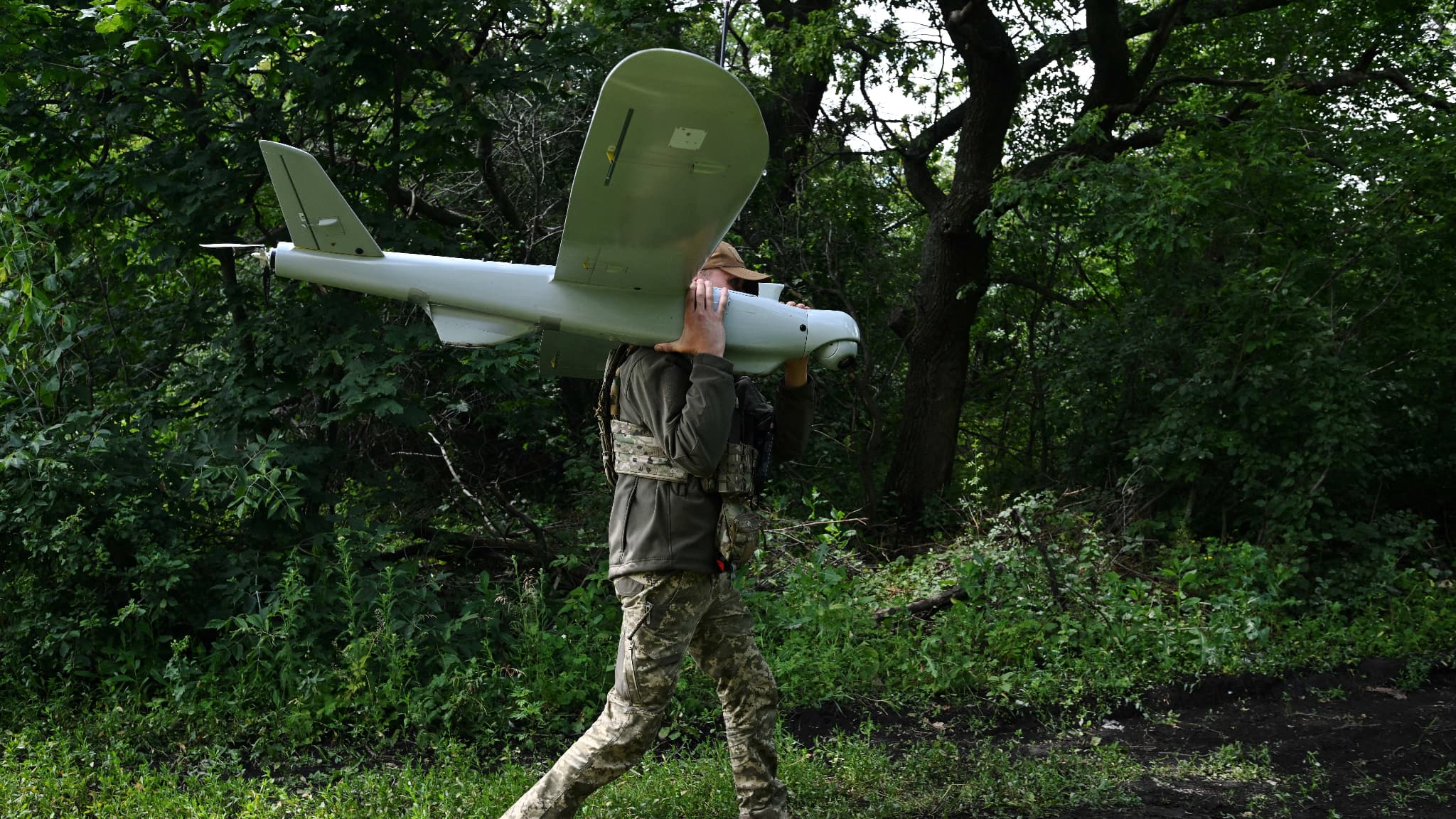 Un militaire ukrainien d transporte un drone de reconnaissance Leleka après son atterrissage sur une position dans la région de Donetsk, le 27 juin 2023
