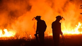 Les pompiers s'efforcent d'éteindre un incendie de forêt dans le village de Vilaza, près de Verin, province d'Ourense, nord-ouest de l'Espagne, le 12 août 2025.