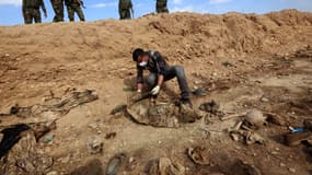 Un homme inspecte un charnier découvert par des forces kurdes en Irak et contenant des restes de membres de la communauté yézidie massacrés par Daesh, en février 2015
