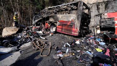 Un pompier inspecte les décombres du bus.