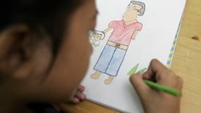 Une enfant thaïlandaise en train de dessiner à Bangkok, le 29 novembre 2005.