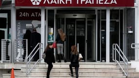 File d'attente devant le distributeur d'une succursale fermée de la Laiki Bnak à Nicosie. Le nouveau projet de loi chypriote sur la taxation des dépôts bancaires exonère les comptes dont le solde est inférieur à 20.000 euros mais ne prévoit aucune mesure