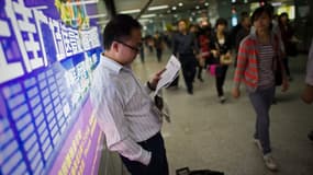 Un homme lit un journal dans le métro de Guangzhou, le 11 novembre 2010 (Photo d'illustration)