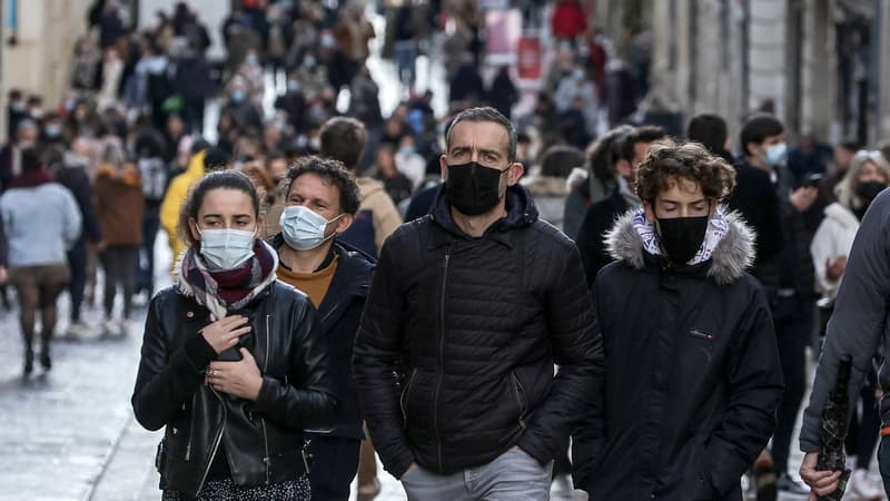 Des piétons portant un masque marchent dans la rue Sainte-Catherine, la plus grande rue commerçante de Bordeaux, dans le sud de la France, le 27 novembre 2021. Depuis le 26 novembre 2021, le masque est à nouveau obligatoire dans les rues du centre-ville de Bordeaux pour éviter la propagation du Covid-19.