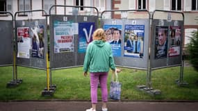 Une femme regarde les affiches électorales des candidats aux législatives à Wissembourg, le 30 juin 2024 dans le Bas-Rhin