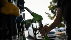 Un automobiliste se sert en essence à une station-service, le 17 juillet 2022 à Toulouse (photo d'illustration).