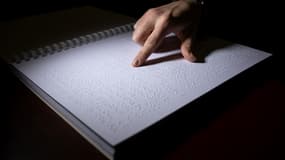 Une femme lit un livre en braille au Centre de transcription et d'édition en braille. PHOTO D'ILLUSTRATION