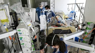 Des soignants s'occupent d'un patient atteint du coronavirus dans l'unité de soins intensifs de l'hôpital Amboise Paré, le 8 mars 2021 à Boulogne-Billancourt, près de Paris