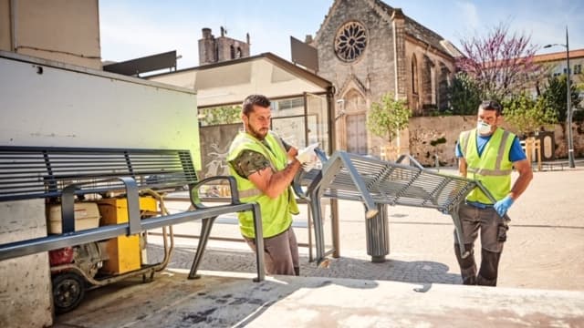 Des agents de voirie retirant les bancs publics de la ville de Béziers.