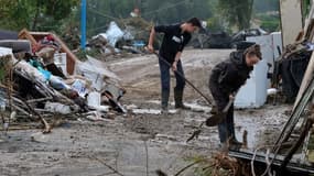 Après les inondations, les habitants de Villegailhenc nettoient les rues.