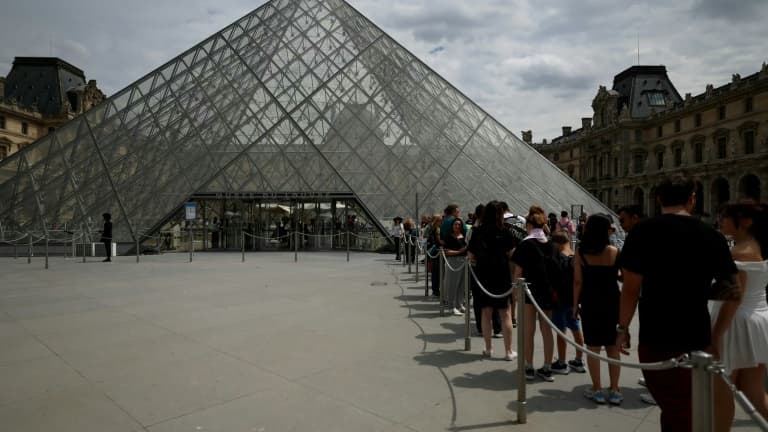 Des visiteurs font la queue devant la pyramide de l'architecteIeoh Ming Pei au musée du Louvre à Paris, le 11 juillet 2024