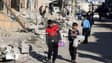 Des enfants partent collecter de l'eau dans la ville de Rafah détruite, le 14 février 2024 