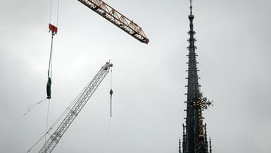 Une grue soulève une statue de Saint-Thomas qui sera replacée au sommet de la flèche de la cathédrale Notre-Dame de Paris, le 24 juillet 2025.
