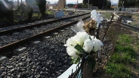 Cette photo d'archives, prise le 21 février 2018, montre des fleurs déposées à un passage à niveau à Millas, dans le sud de la France, où un bus scolaire et un train sont entrés en collision en décembre 2017, faisant six morts