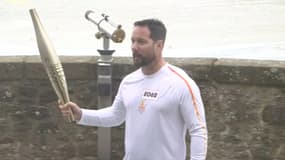 Thomas Pesquet portant la flamme olympique sur les remparts du Mont-Saint-Michel (Manche), le vendredi 21 mai 2024.