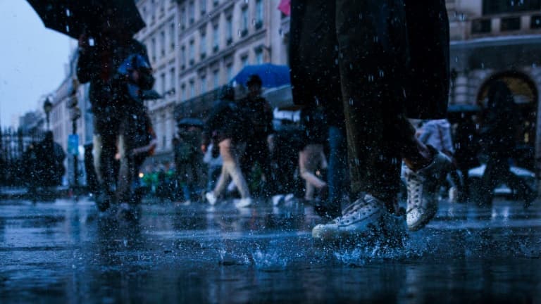 Des piétons traversent une rue inondée en raison de fortes pluies, à Paris, le 17 octobre 2024.