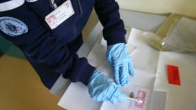 Un gendarme travaille sur un prélèvement d'ADN, le 12 octobre 2007 dans les locaux de la gendarmerie à Cergy-Pontoise. (PHOTO D'ILLUSTRATION)