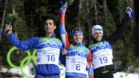 Martin Fourcade (à la droite de d'Evgeny Ustyugov, au centre) sur le podium de la mass-start aux JO de Vancouver, le 22 février 2010