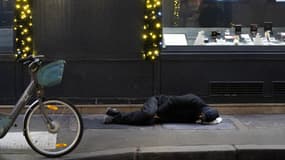 Un sans-abri essaye de dormir dans le froid parisien le 8 janvier 2024