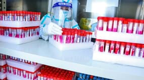 Un technicien de laboratoire dépose des échantillons de tests du Covid, le 23 octobre 2021 à Zhangye, en Chine.