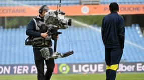 Un caméraman en train de filmer un joueur de Ligue 1 en avril 2024