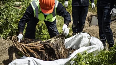 Un homme sur une fosse commune à Raqa en avril 2019