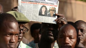 Un journaliste malien brandit un quotidien local, "L'Essor", montrant la photo des deux journalistes dans les rues de Bamako, le 2 novembre.