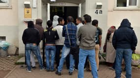 Des réfugiés font la queue devant un centre d'enregistrement de demandes d'asile