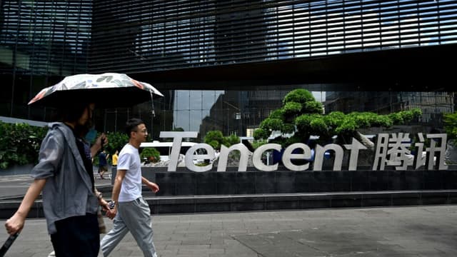 Cette photo prise le 26 mai 2021 montre des personnes passant devant le siège de Tencent dans la ville de Shenzhen, dans le sud de la Chine, dans la province du Guangdong
