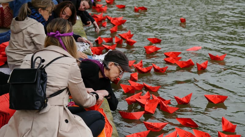 Des militants des droits des femmes placent des bateaux en papier portant l'âge et le prénom des victimes de féminicides sur la Seine lors d'un hommage aux 900 féminicides signalés qui ont eu lieu depuis la première élection de l'actuel président français, sur le quai des Célestins à Paris, en mai 14, 2024.