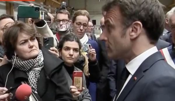 Le député Emmanuel Fernandes du Bas-Rhin, bâillon 49.3 sur le visage, devant Emmanuel Macron à l'usine Mathis le mercredi 19 avril 2023.