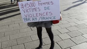 Une femme tient une pancarte dénombrant 21.500 femmes victimes de violences par an en France, le 29 octobre 2017 à Marseille. 