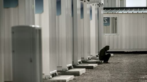 Un migrant est assis sur les marches d'une maison en préfabriquée dans la jungle de Calais, le 16 février 2016 Un migrant est assis sur les marches d'une maison en préfabriquée dans la jungle de Calais, le 16 février 2016