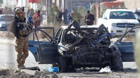 Un policier près d'une voiture détruite par une attaque suicide, à Kaboul, le 13 novembre 2019.