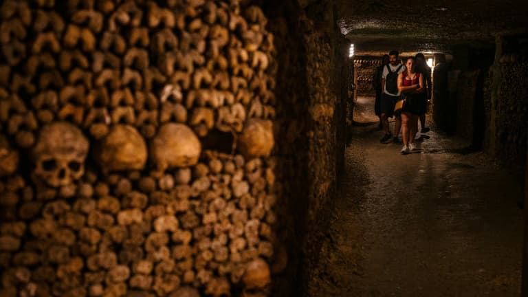 Des touristes visitent les catacombes de Paris, le 12 août 2025